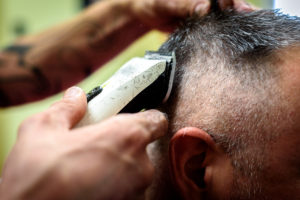 Zuerst sollten die Kopfhaare getrimmt werden, bevor die Rasur einer Glatze beginnt.